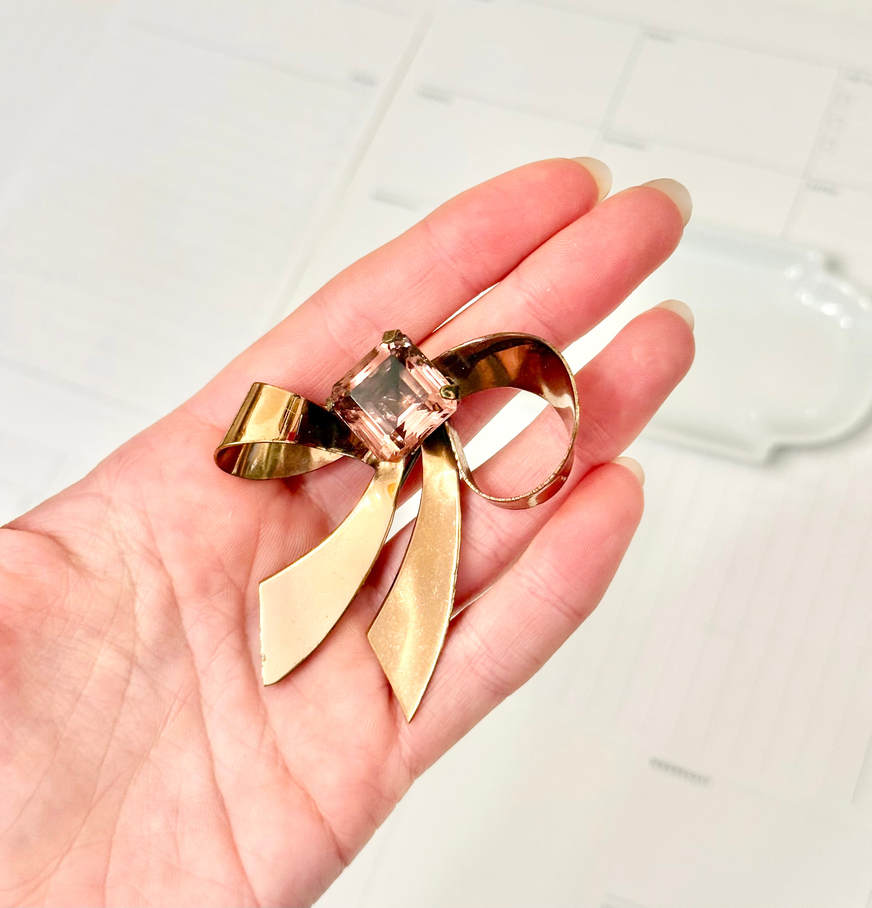 1960's most feminine brass bow with purple glass stone....