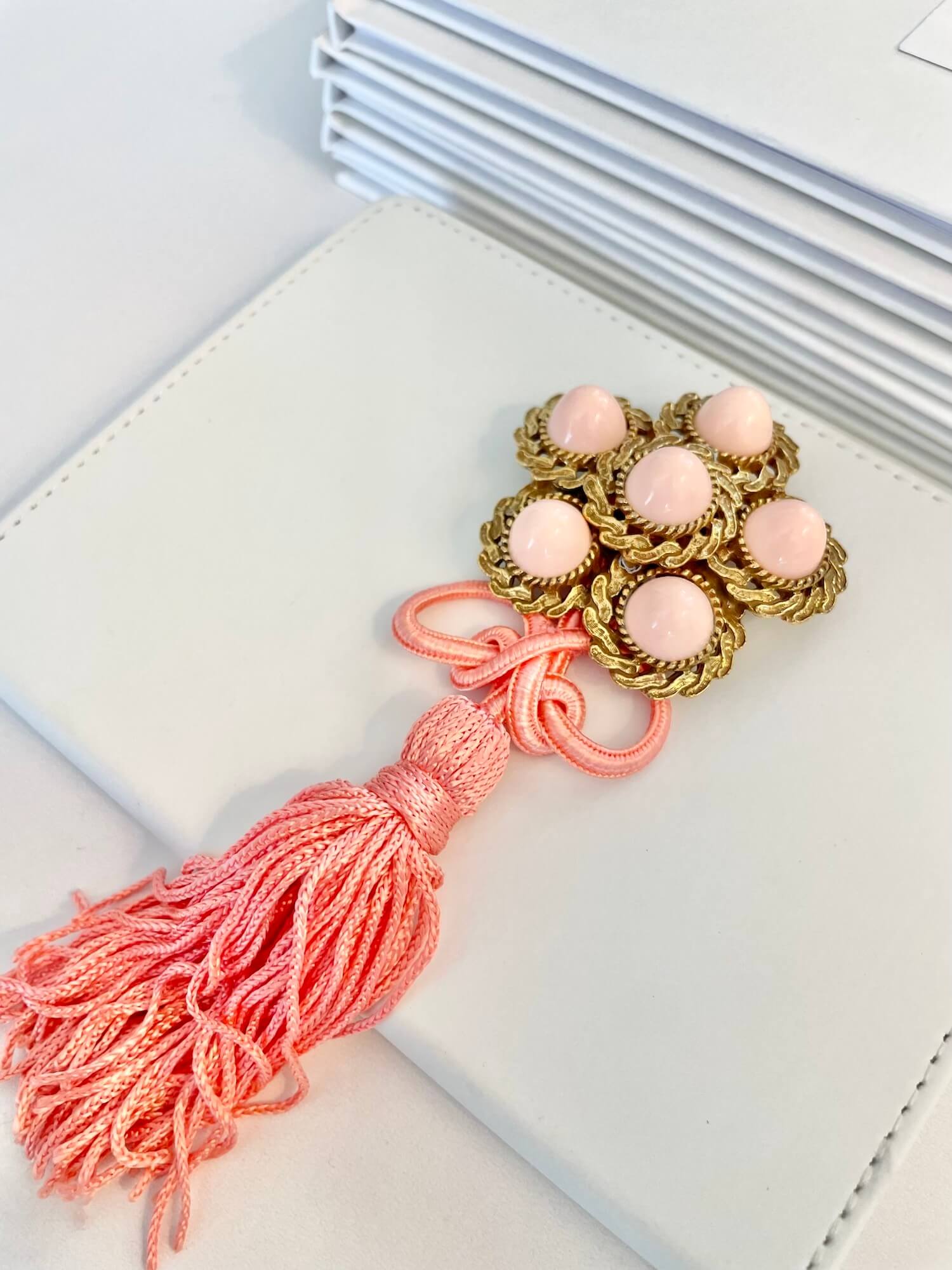 Vintage 1960’s faux angel skin coral brooch, with added tassel for a bit of fun flair!