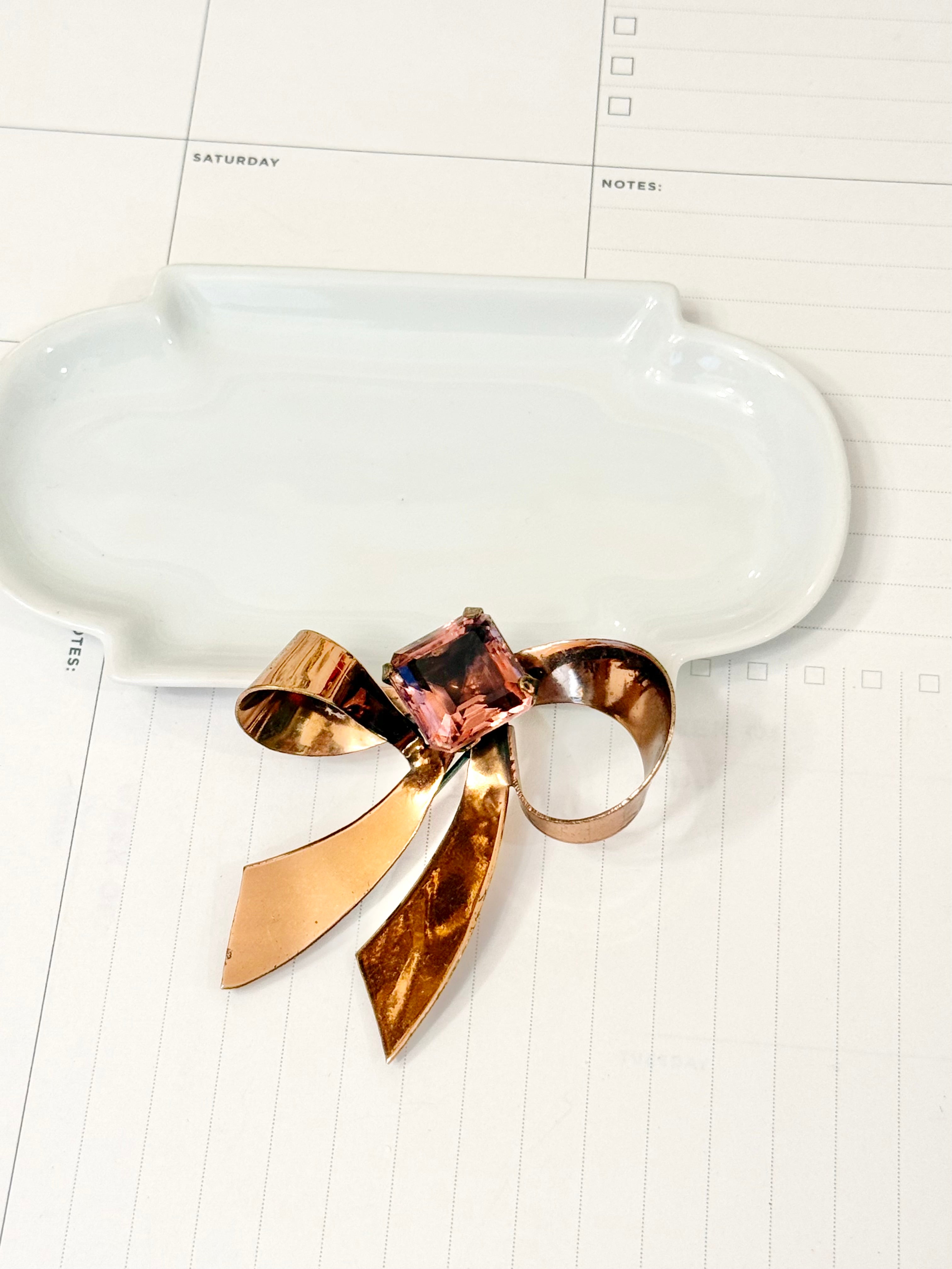 1960's most feminine brass bow with purple glass stone....