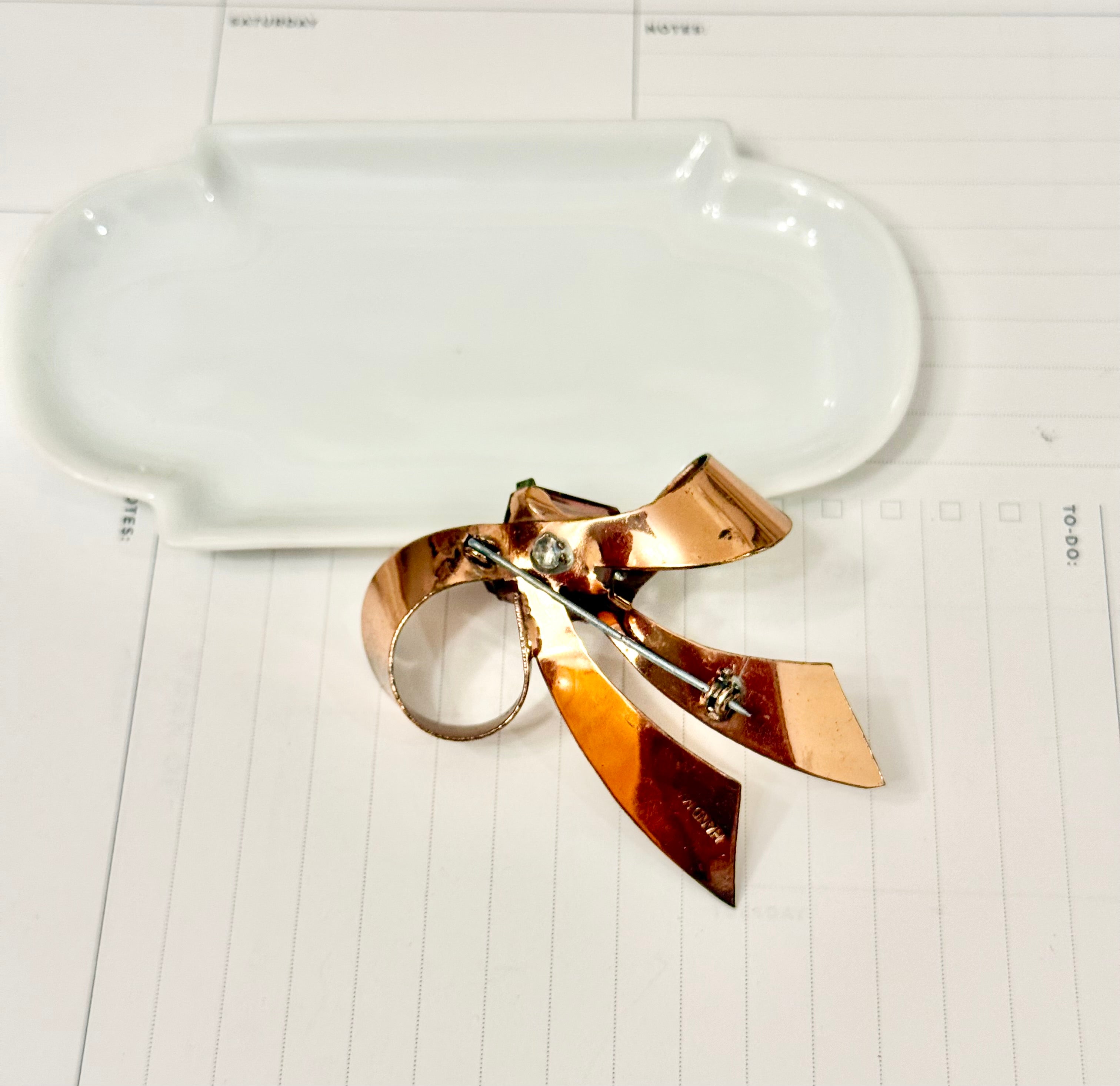 1960's most feminine brass bow with purple glass stone....